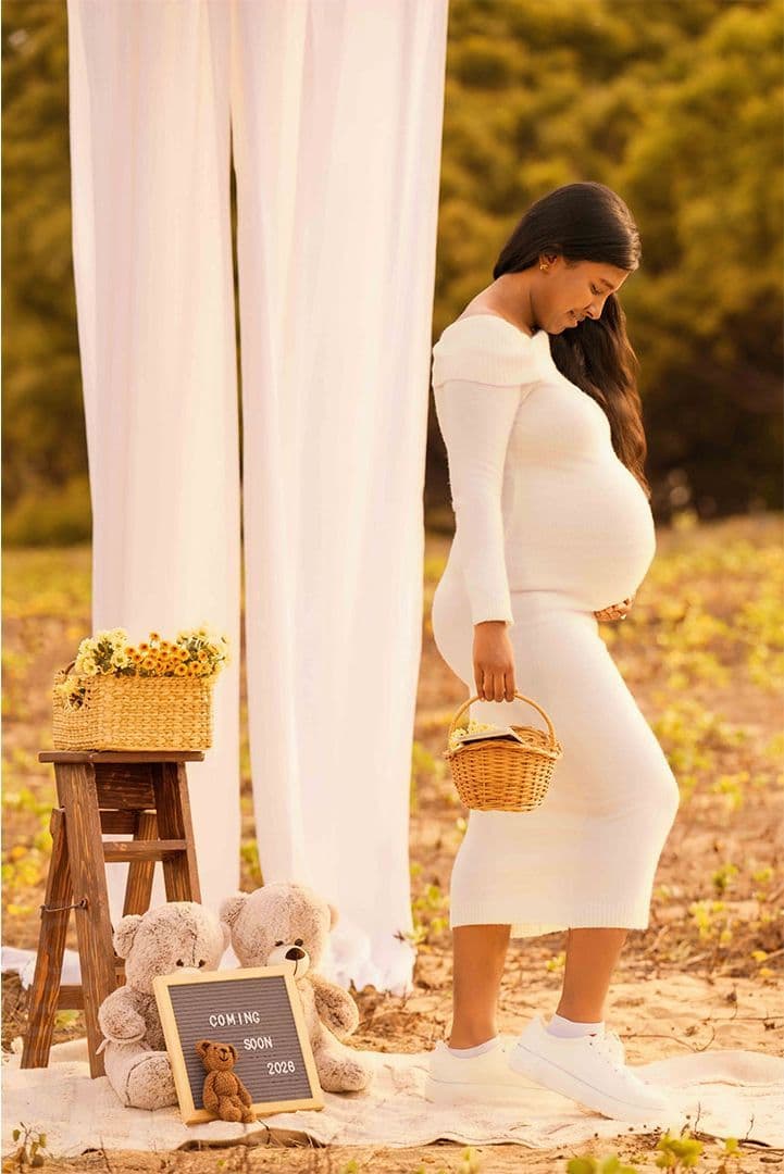 Maternity portrait beside flowing white drapes at sunset