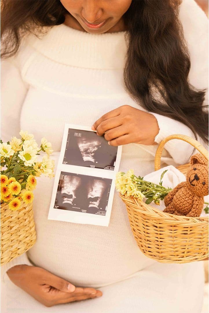Close-up maternity detail with sonogram print and flowers