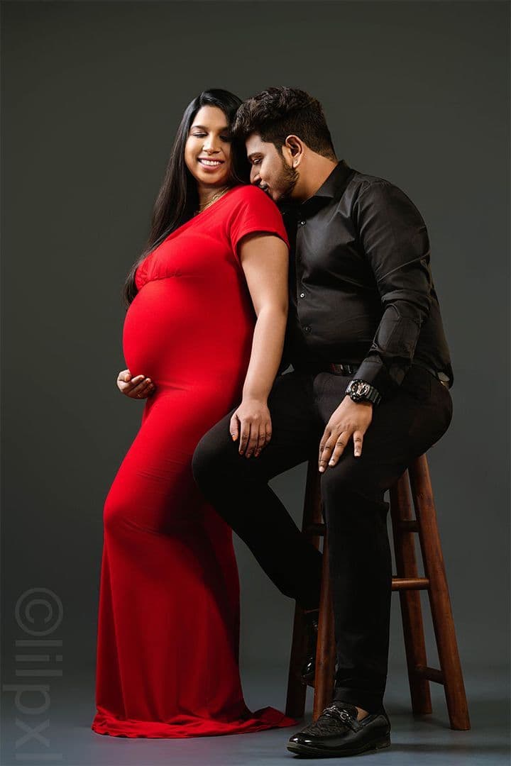 Couple portrait, maternity in red gown with partner in black suit