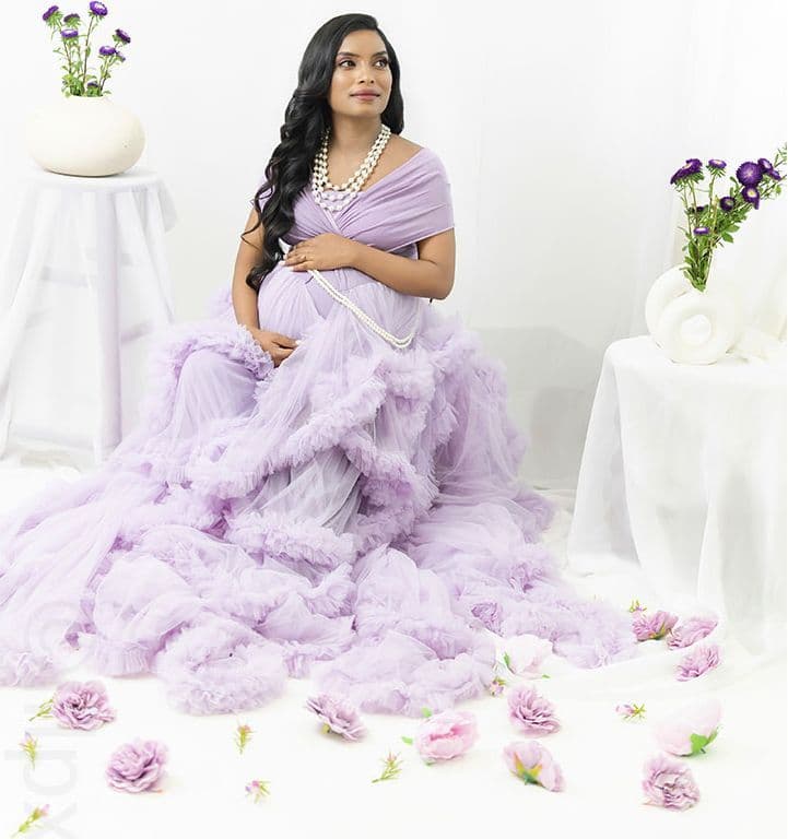 Maternity portrait in a lilac ballgown, all-white studio setting