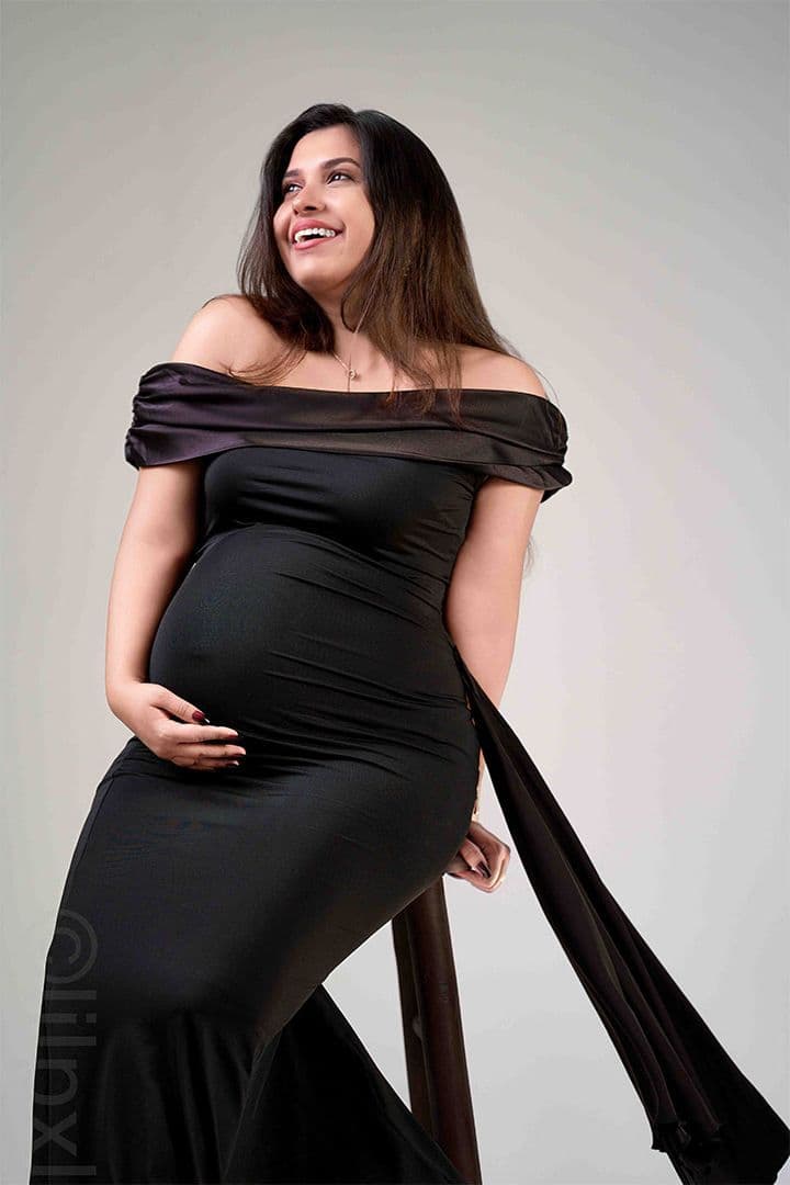 Maternity portrait in a black gown, joyful expression
